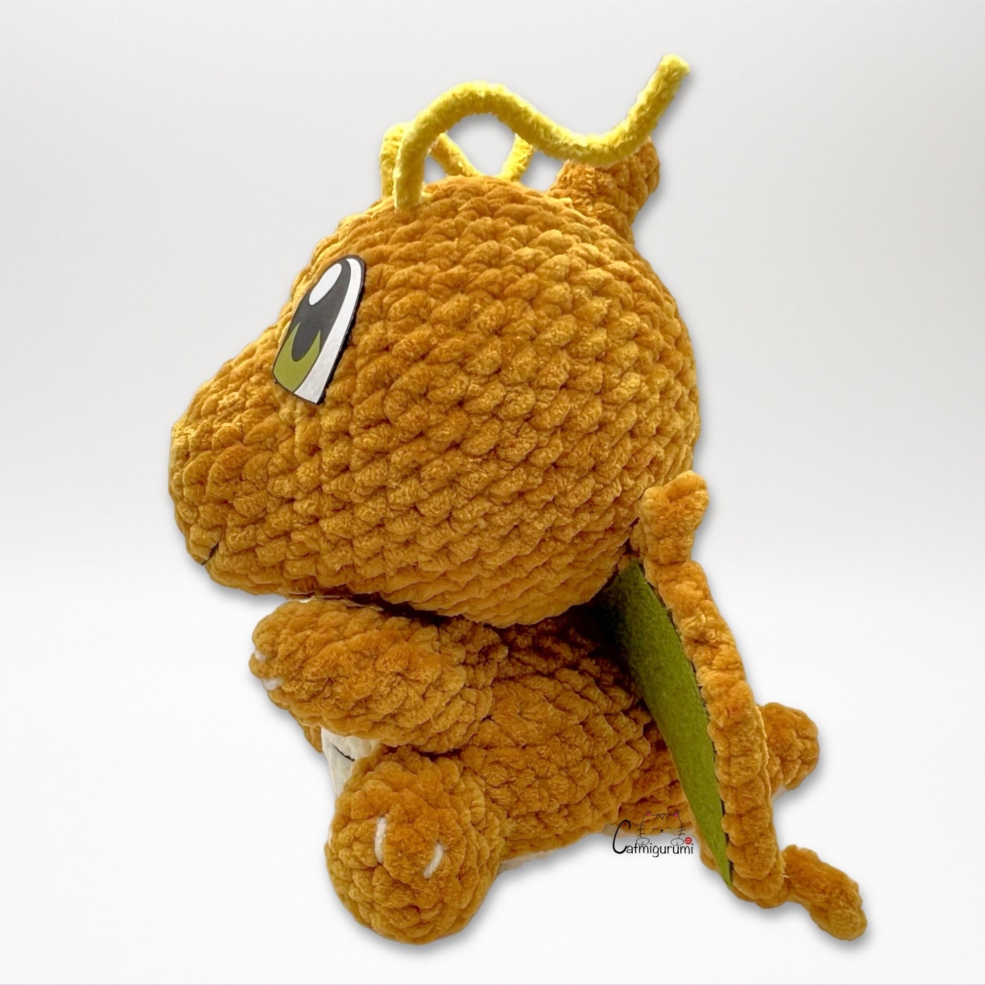 Side view of flying yellow dragon amigurumi crochet plush